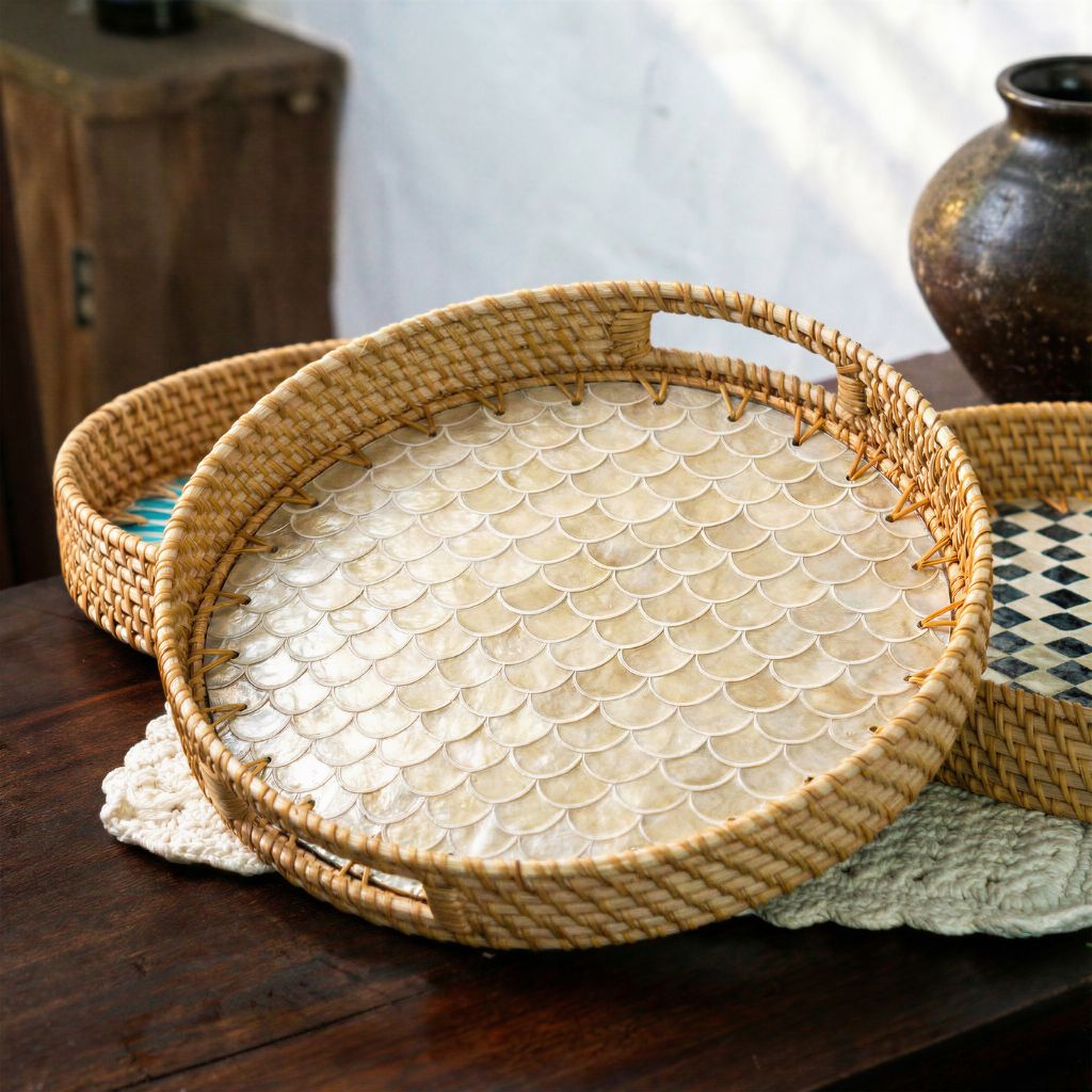 Round woven rattan tray with a scalloped shell-patterned insert, displayed on a dark wooden table alongside other decorative trays.